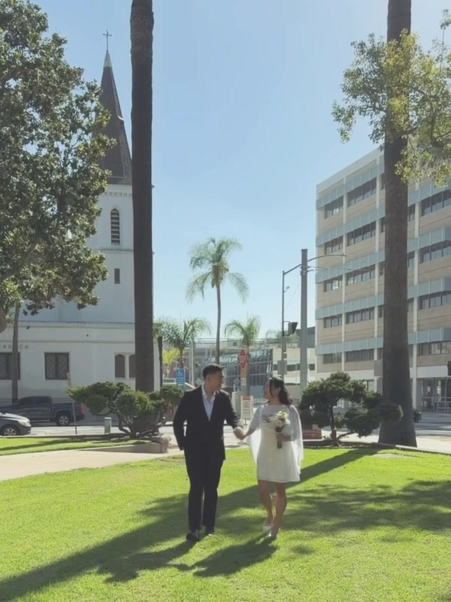 Brendan and Valeria walking hand in hand across the lawn